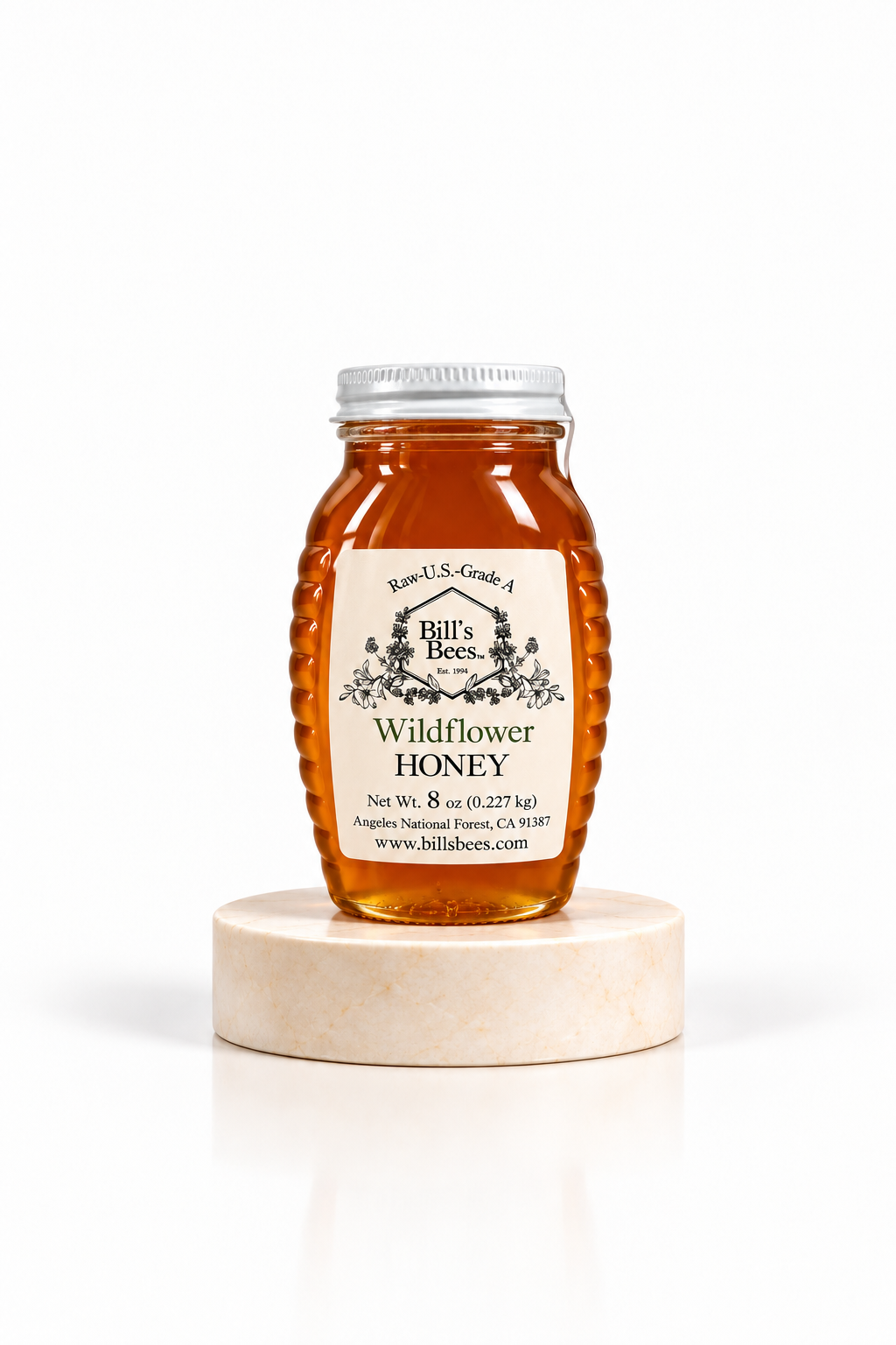 8 oz Bill's Bees Wildflower Honey jar on a marble pedestal, portrait format