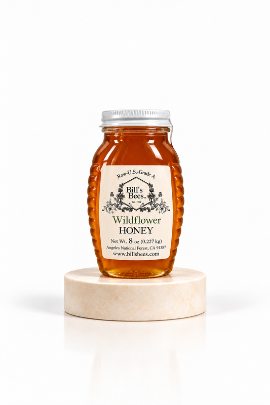 8 oz Bill's Bees Wildflower Honey jar on a marble pedestal, portrait format