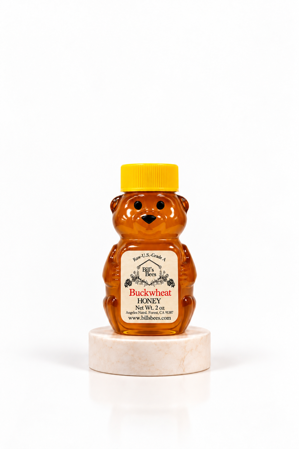 2 oz Bill's Bees Buckwheat Honey squeeze bear on a marble pedestal, portrait format