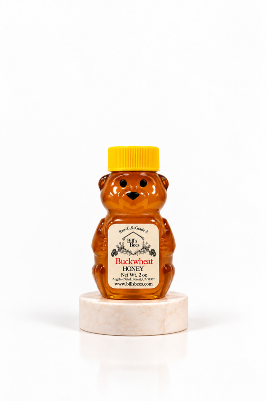 2 oz Bill's Bees Buckwheat Honey squeeze bear on a marble pedestal, portrait format