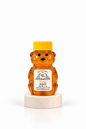 2 oz Bill's Bees Orange Blossom Honey squeeze bear on a marble pedestal, portrait format