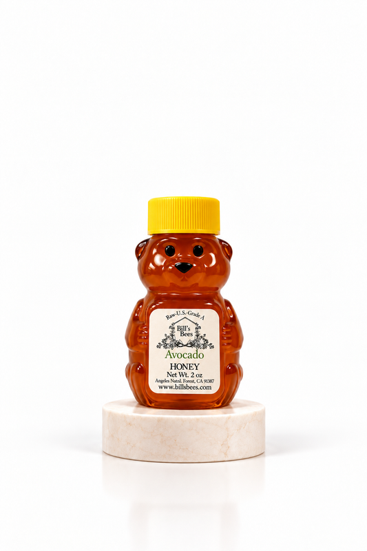 2 oz Bill's Bees Avocado Blossom Honey squeeze bear on a marble pedestal, portrait format