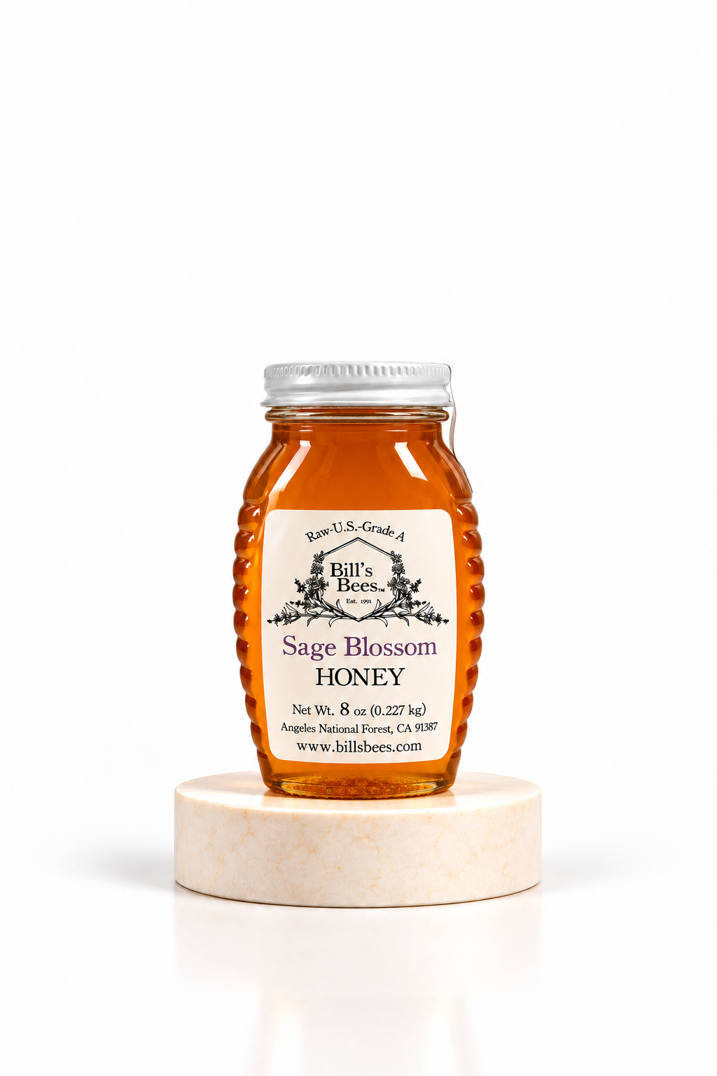 8 oz Bill's Bees Sage Blossom Honey jar on a marble pedestal, portrait format