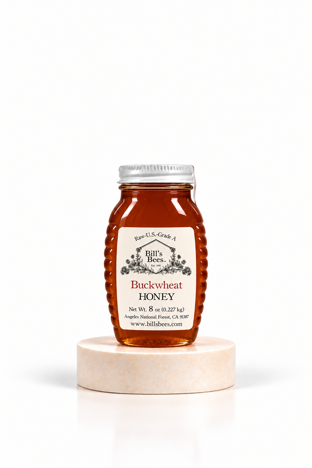 8 oz Bill's Bees Buckwheat Honey jar on a marble pedestal, portrait format