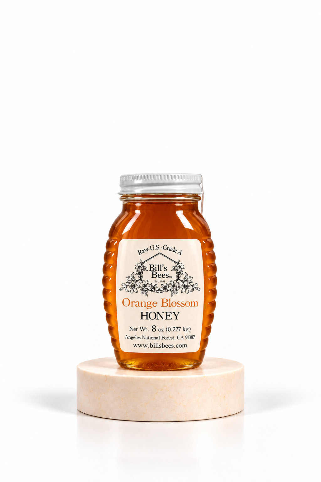 8 oz Bill's Bees Orange Blossom Honey jar on a marble pedestal, portrait format