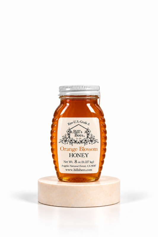 8 oz Bill's Bees Orange Blossom Honey jar on a marble pedestal, portrait format